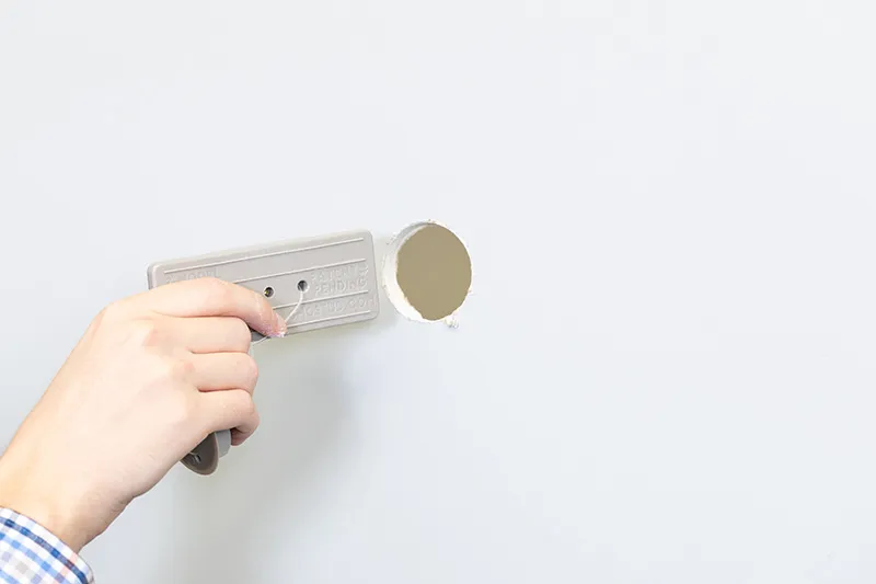 Inserting the backing plate behind the drywall